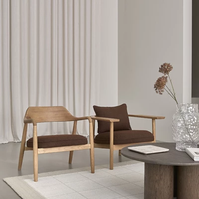 Två fåtöljer i trä med röd klädsel stående bredvid varandra