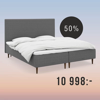 Grå säng med gavlar på regnbågsfärgad bakgrund