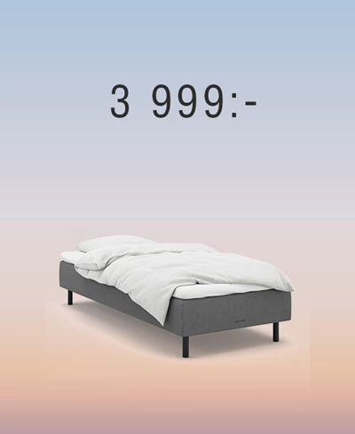 Grå boxmadrass mot regnbågsfärgad bakgrund