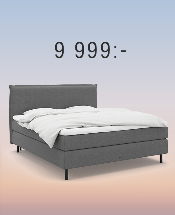 Grå kontinentalsäng med gavel mot regnbågsfärgad bakgrund