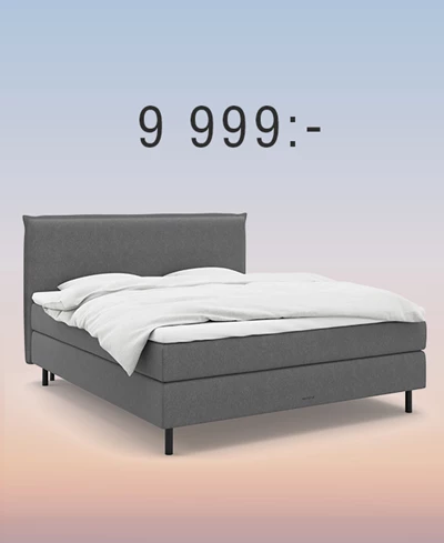 Grå kontinentalsäng med gavel mot regnbågsfärgad bakgrund