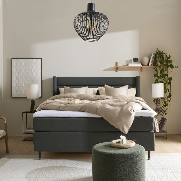 Modernt sovrum med en distinkt grön säng och konstnärliga väggdekorationer som tillför en känsla av lyx