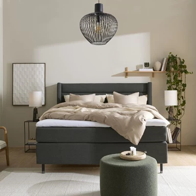 Modernt sovrum med en distinkt grön säng och konstnärliga väggdekorationer som tillför en känsla av lyx