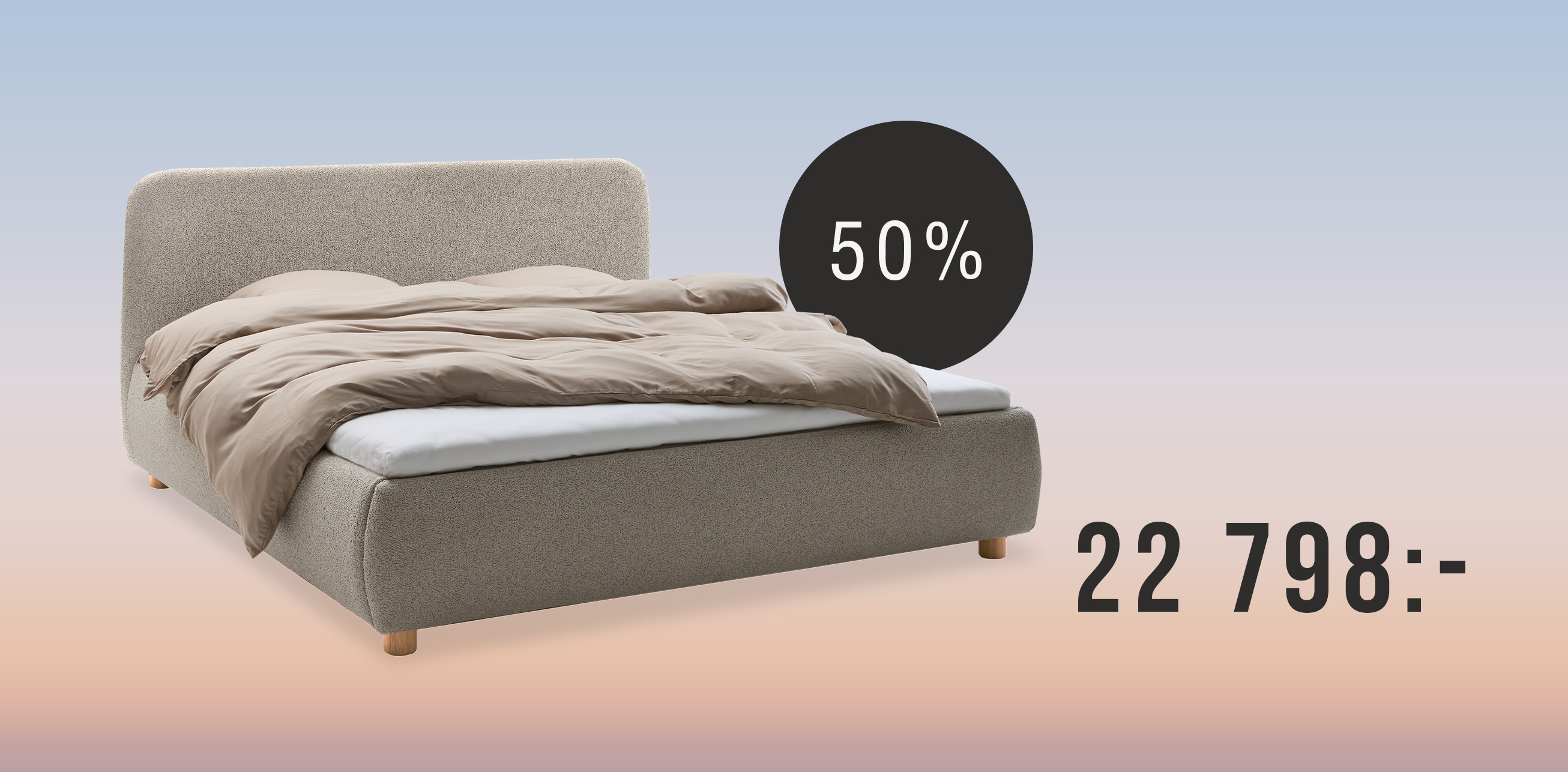 Ljusgrå säng med gavel mot regnbågsfärgad bakgrund