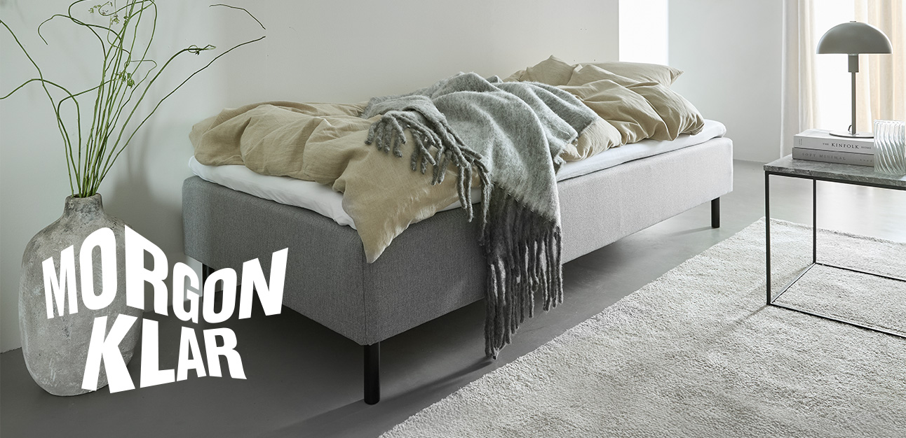 Enkel­säng i grått placerad i sovrummet.