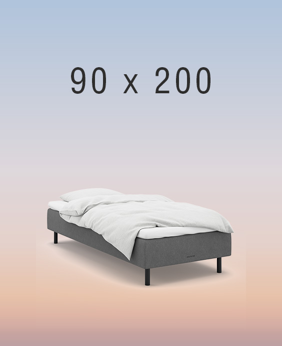 Grå boxmadrass på regnbågsfärgad bakgrund