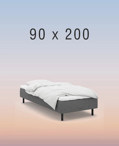 Grå boxmadrass på regnbågsfärgad bakgrund