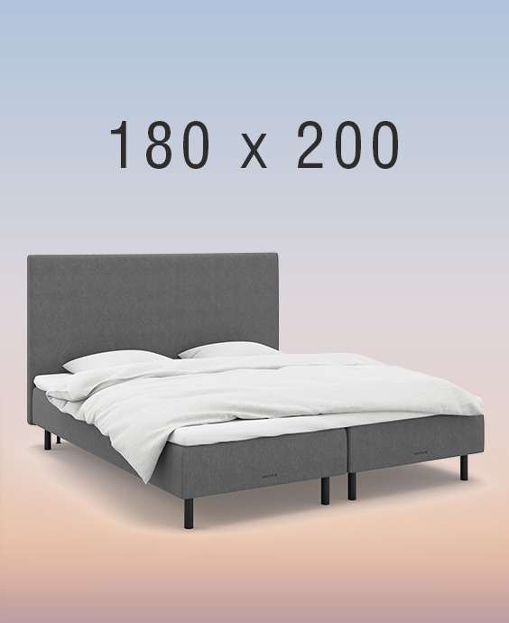 Grå boxmadrass på regnbågsfärgad bakgrund