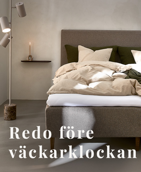 Grå bäddad resårbotten med en golvlampa bredvid