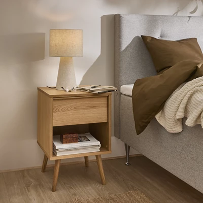 Ljust sängbord bredvid trä