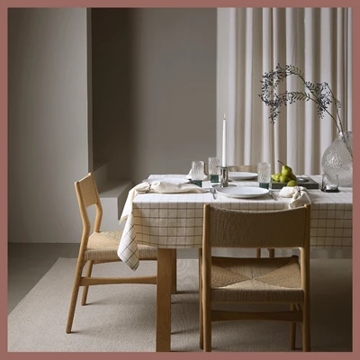 Dukat julbord med rutig duk och matstolar i trä.