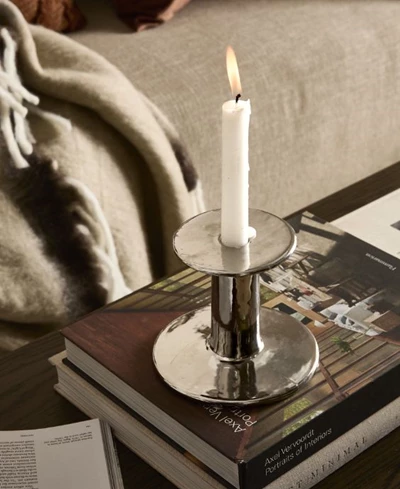 Ljusstake i stål på en hög med böcker.