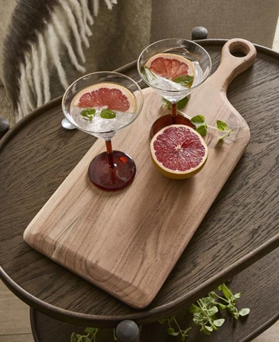 Skärbräda med drinkar och en grapefrukt ovanpå.