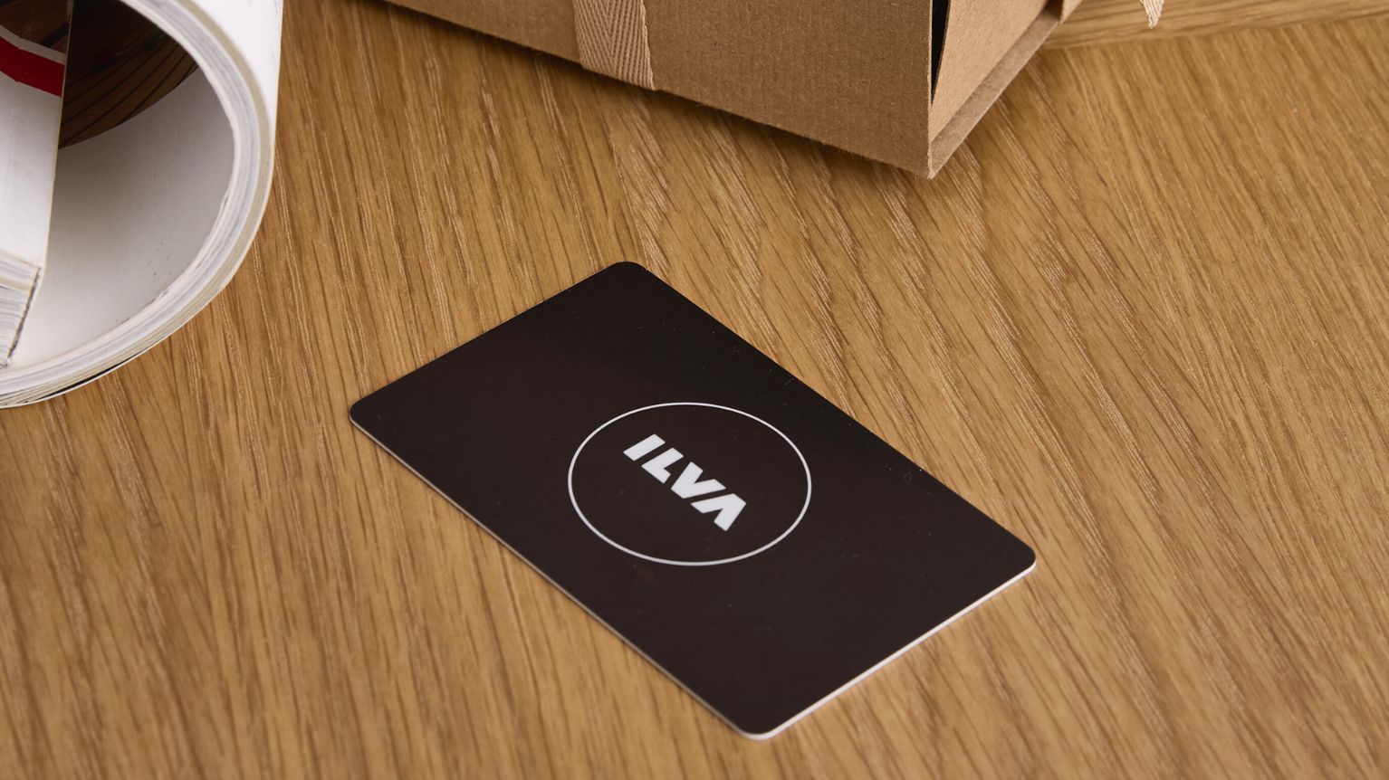 Svart presentkort liggande på träbord.