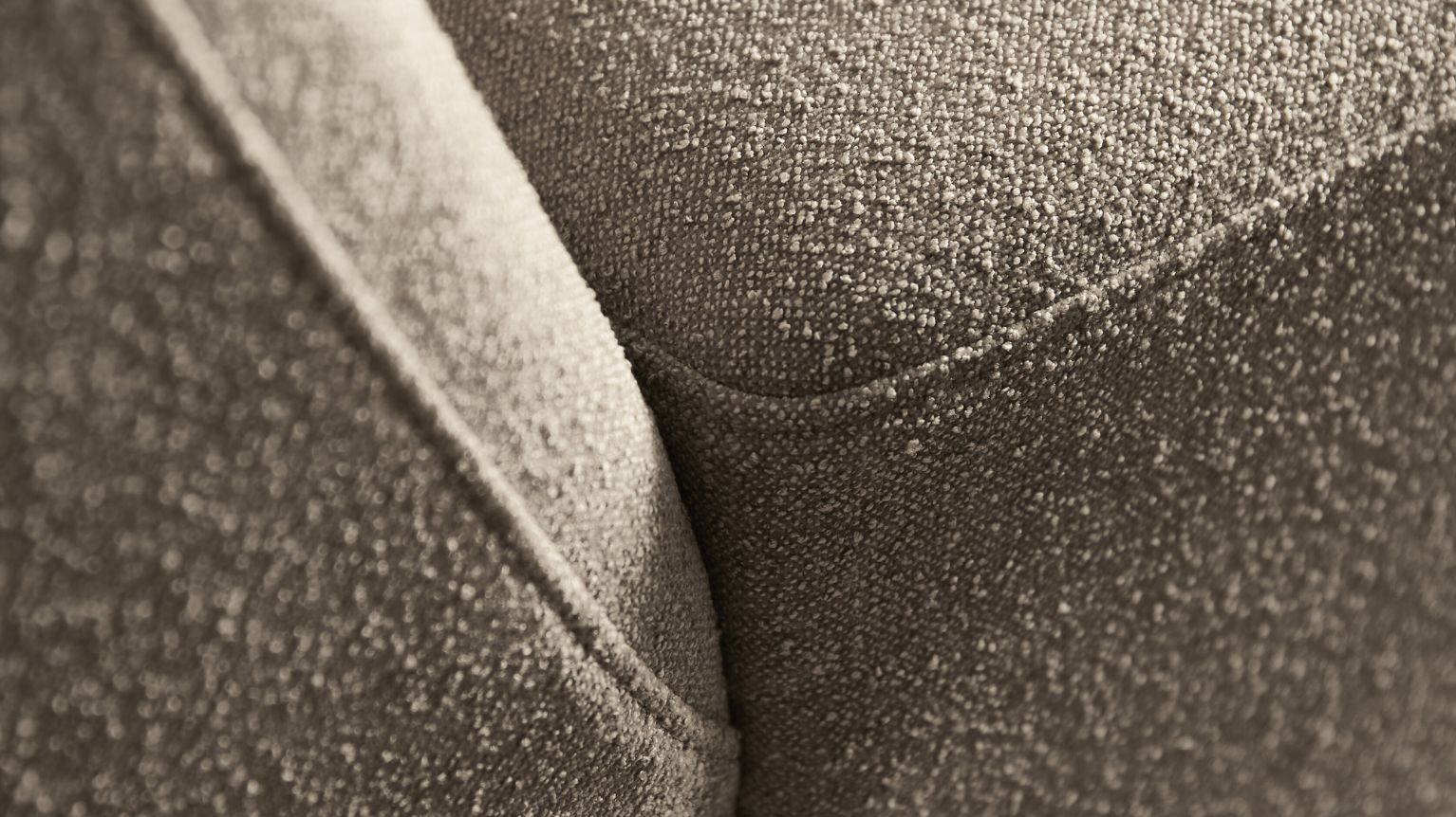 Närbild av grått tyg på soffa.