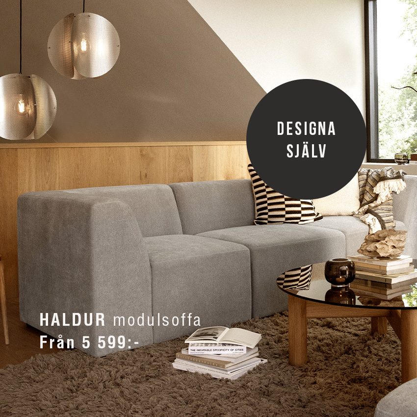 Grå modulsoffa stående på matta.