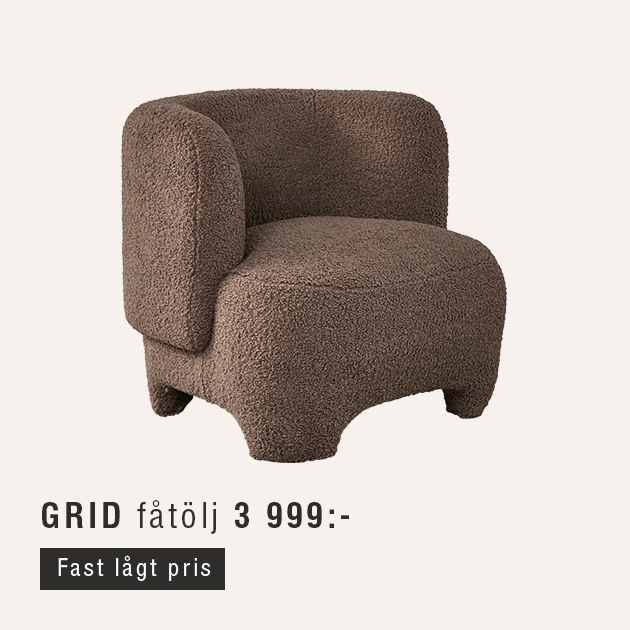 Brun och fluffig fåtölj mot beige bakgrund.