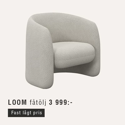 Vit fåtölj mot beige bakgrund.