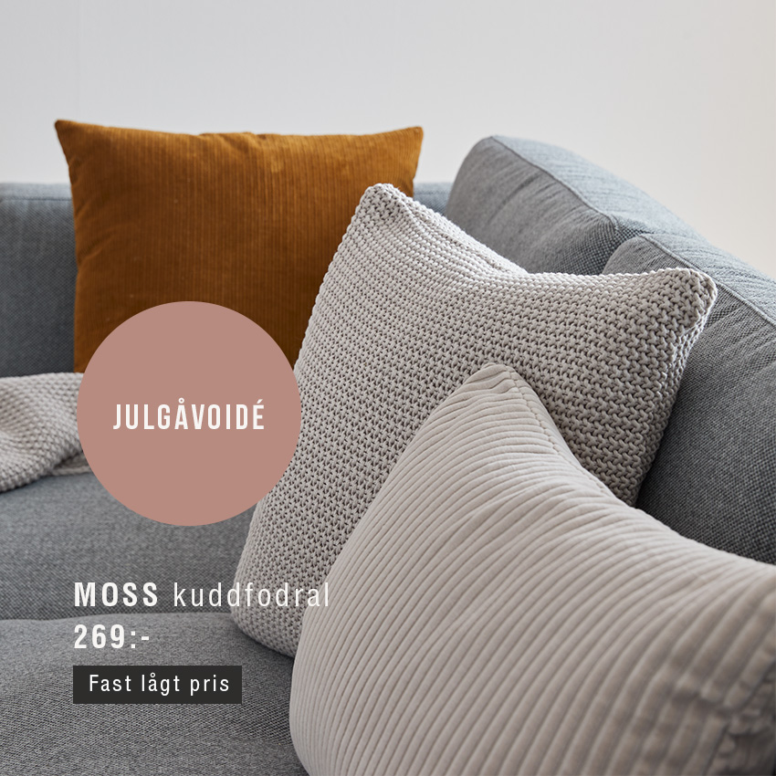 Kuddar i grått och orange liggande på grå soffa.