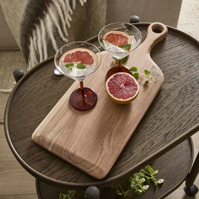 Skärbräda i trä med drinkglas ovanpå