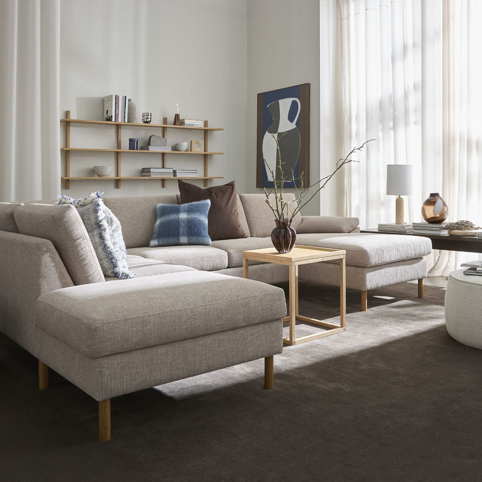 Grå hörnsoffa med kuddar och träbord i vardagsrum