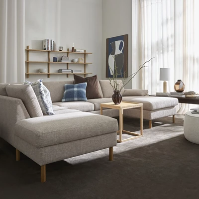 Grå hörnsoffa med kuddar och träbord i vardagsrum