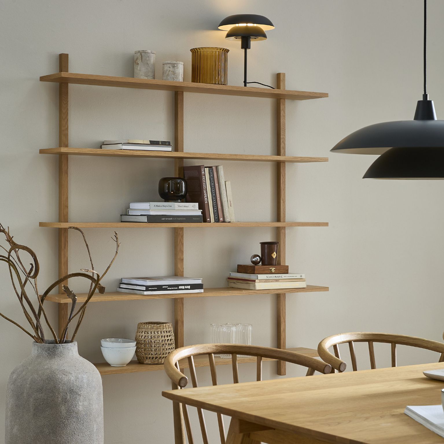 Modern vägg­hylla med flera hyllplan i ett ljust vardagsrum.