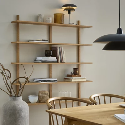 Modern vägghylla med flera hyllplan i ett ljust vardagsrum.