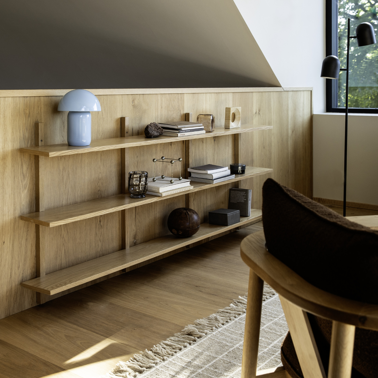 Vägghylla i trä som hänger på en trävägg.