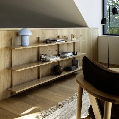 Vägghylla i trä som hänger på en trävägg.