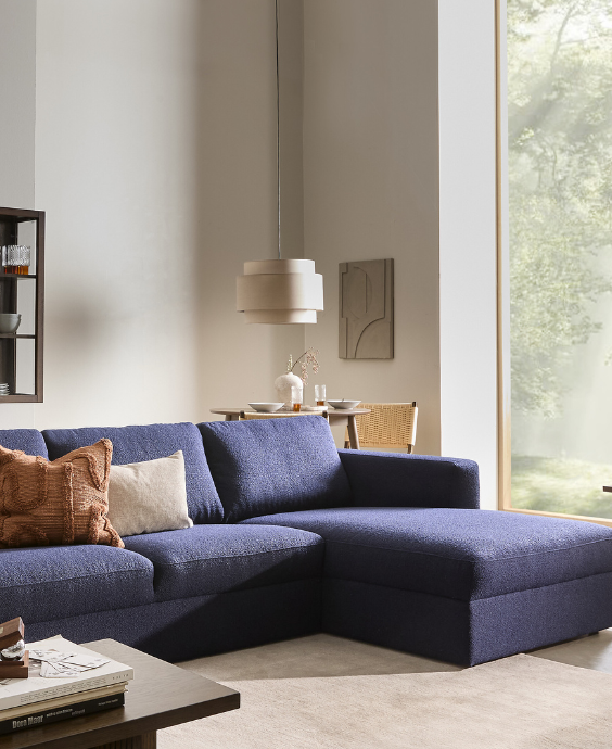 Blå soffa med divan i ett mysigt vardagsrum