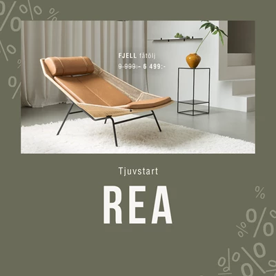 Beige loungestol FJELL i modernt vardagsrum med rea-skylt, neutrala färger och stilrena hyllor i bakgrunden.