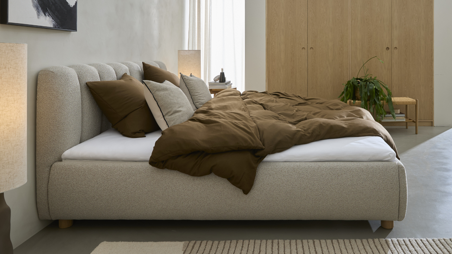 Säng i grå sedd från sidan, stående i sovrum