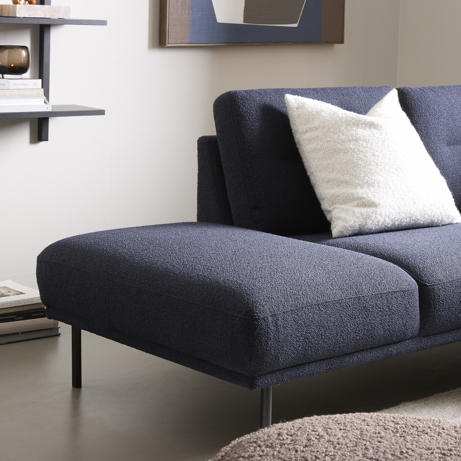 Närbild av puffavslutning på mörkblå soffa