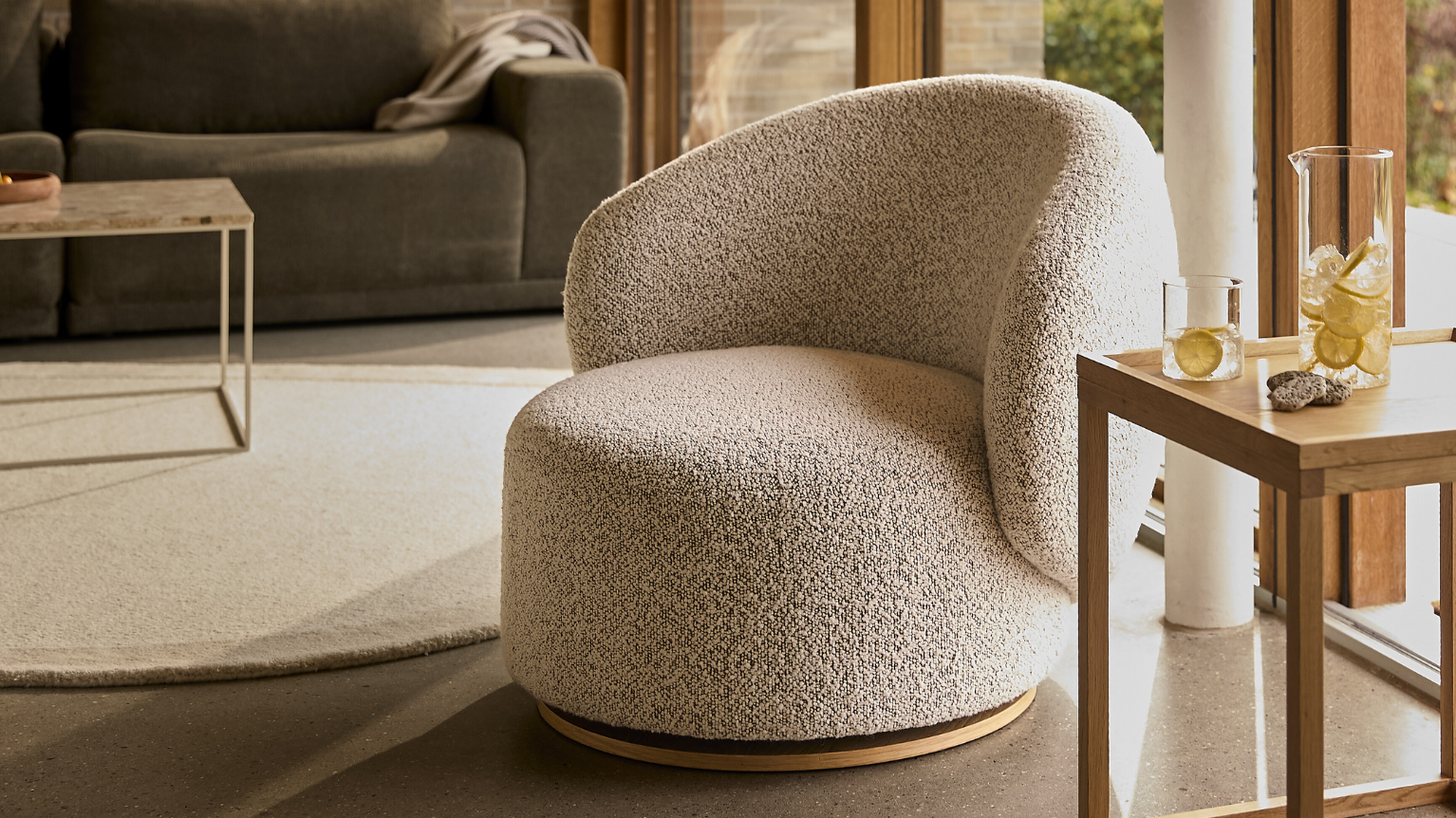 Rund grå fåtölj placerad i vardagsrummet.