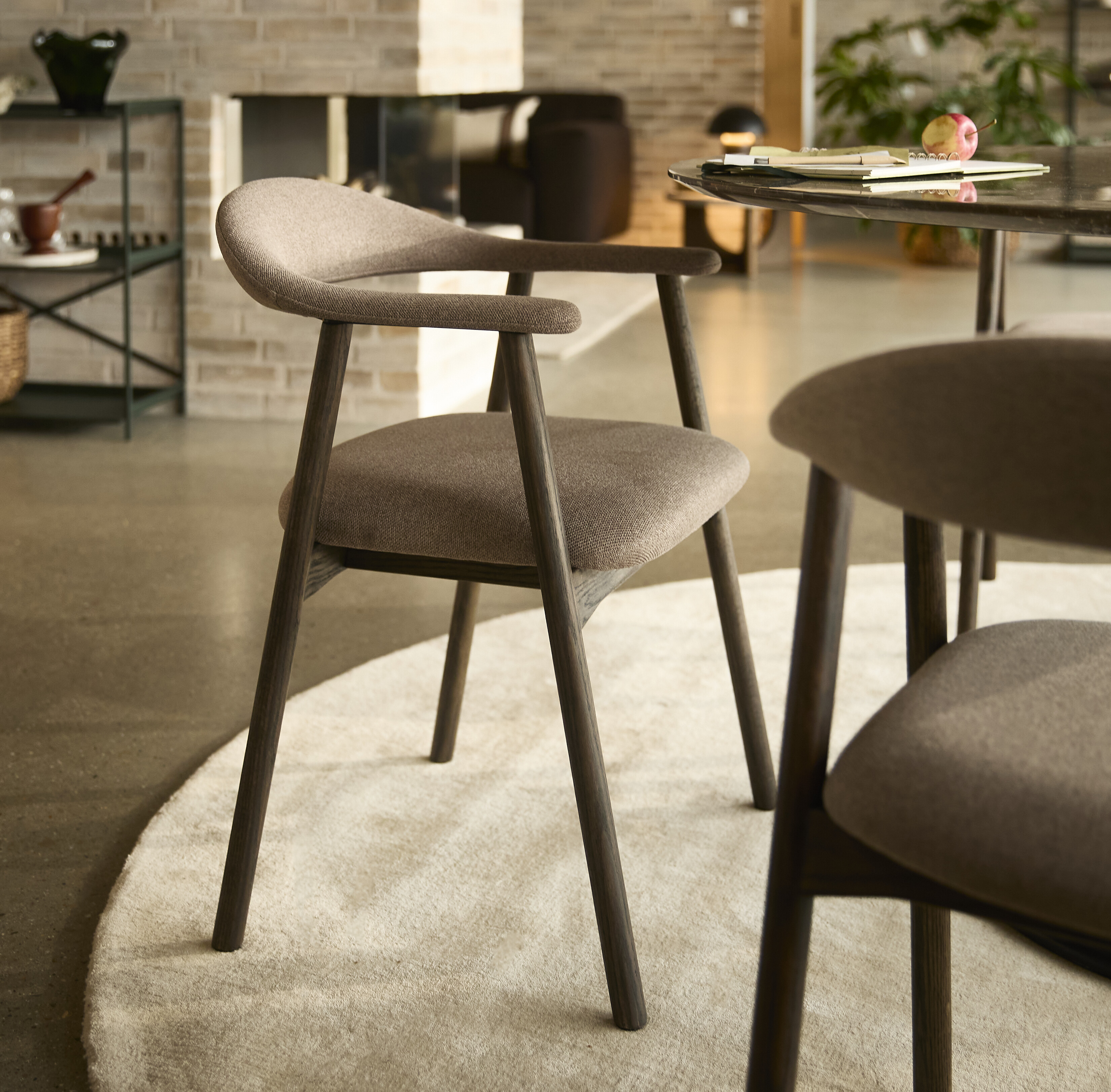 Klädd matstol i mörk textil.