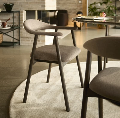 Klädd matstol i mörk textil.