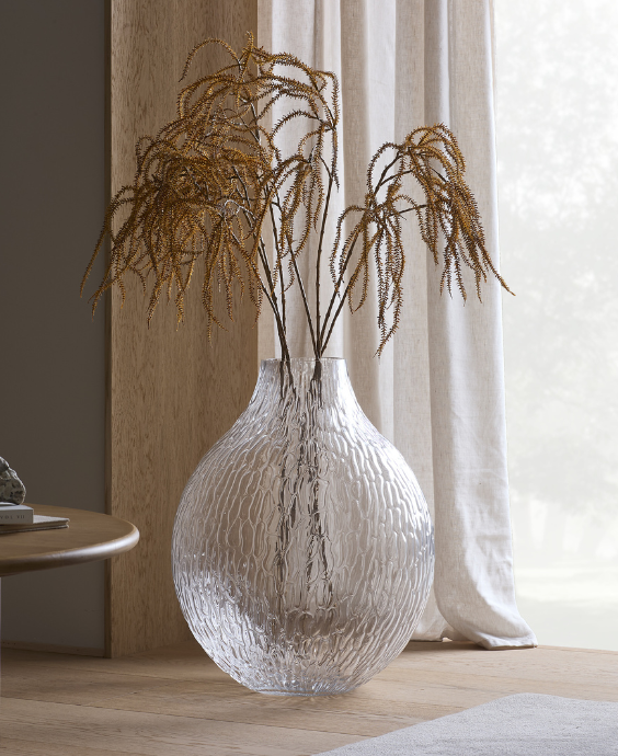 Vit glasvas placerad på golvet.