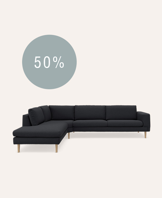 Hjørnesofa i mørkeblå betræk på beige baggrund