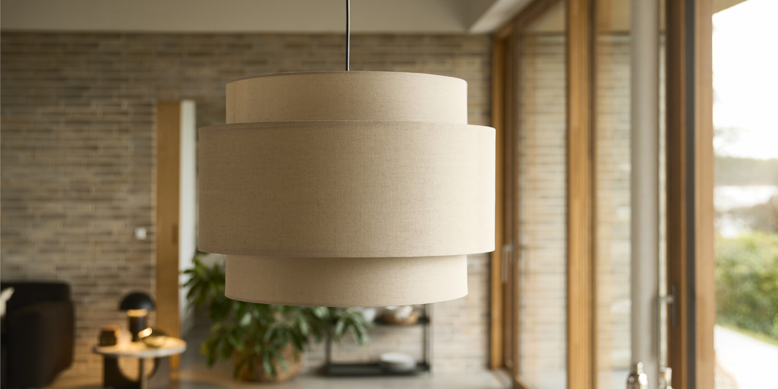 Stor pendellampa i textil som hänger i vardagsrummet.