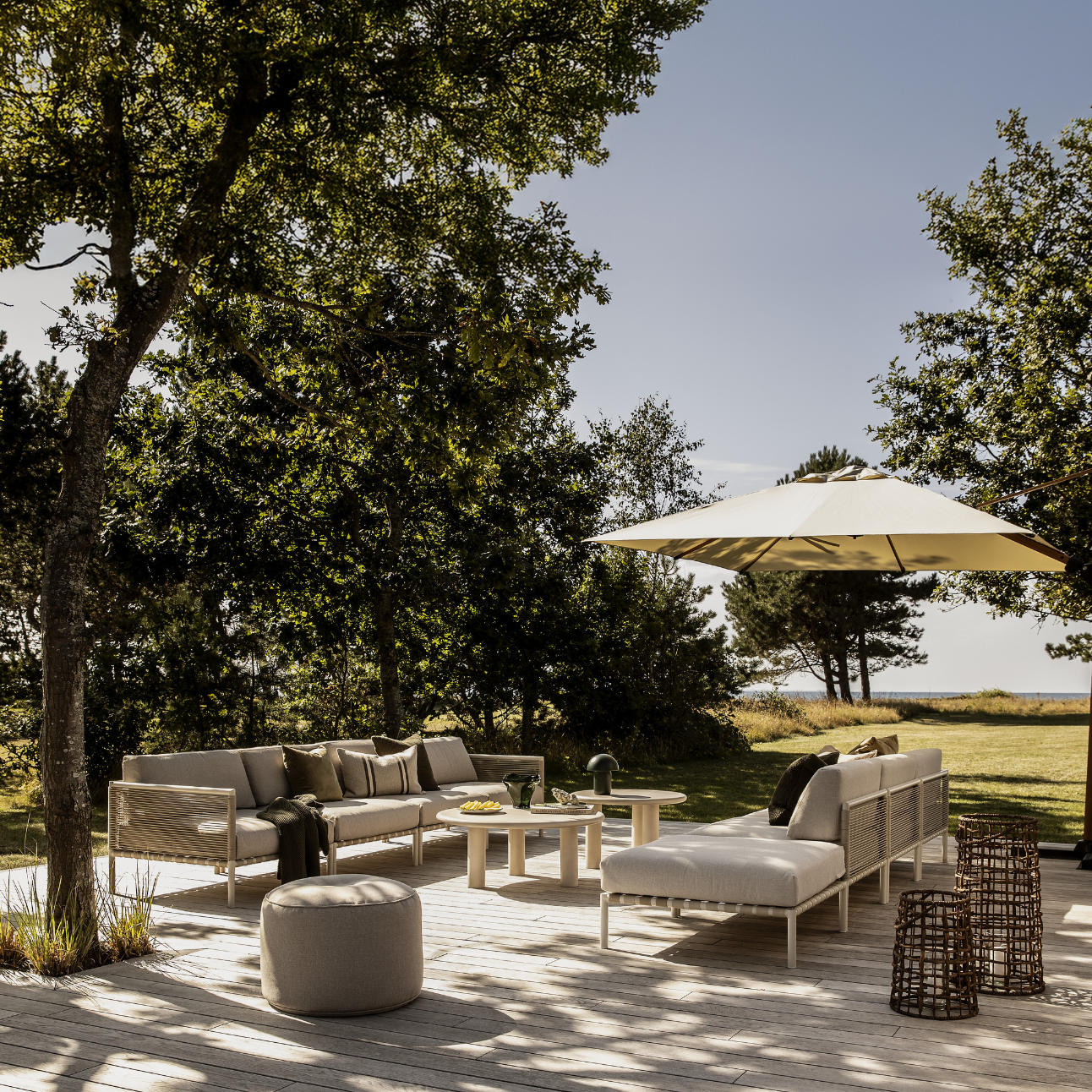 Terrassmiljö med loungemöbler i ljusa färger.