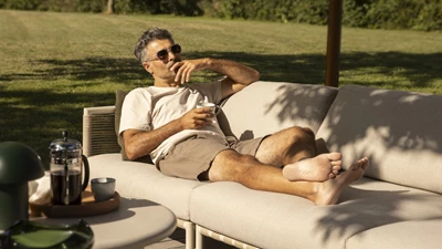 Man som njuter av solen i loungesoffa