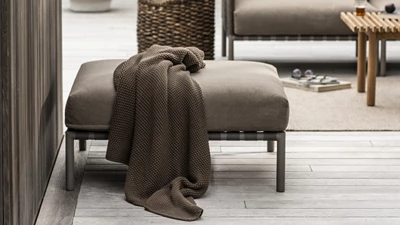 Loungepuff i mörk färg på terrassen.