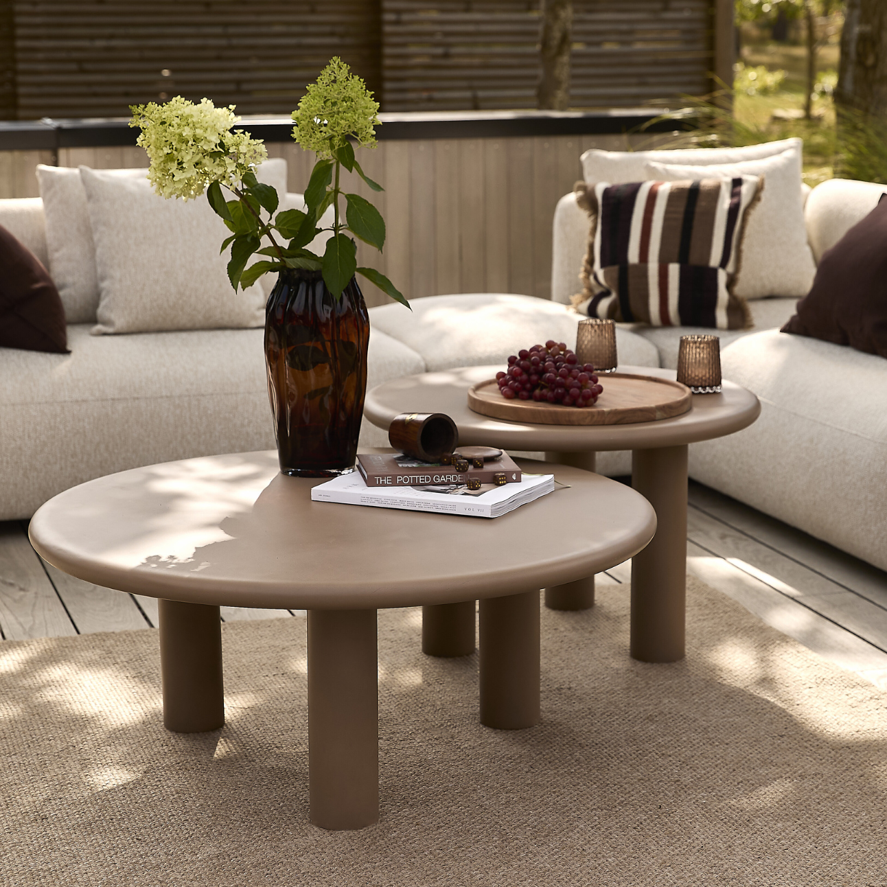 Två loungebord framför en ljus loungesoffa