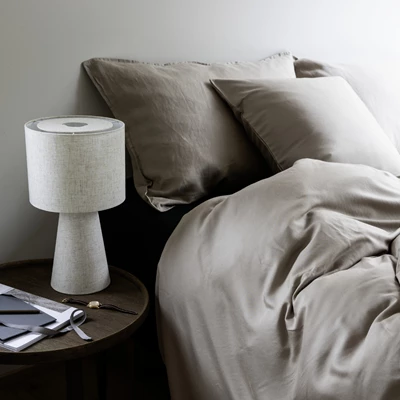 Bäddad säng i neutrala färger