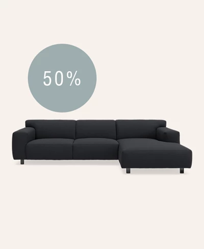 Mørkeblå chaiselongsofa på beige baggrund