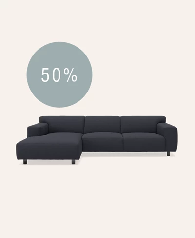 Mørkeblå sofa med chaiselong på beige baggrund