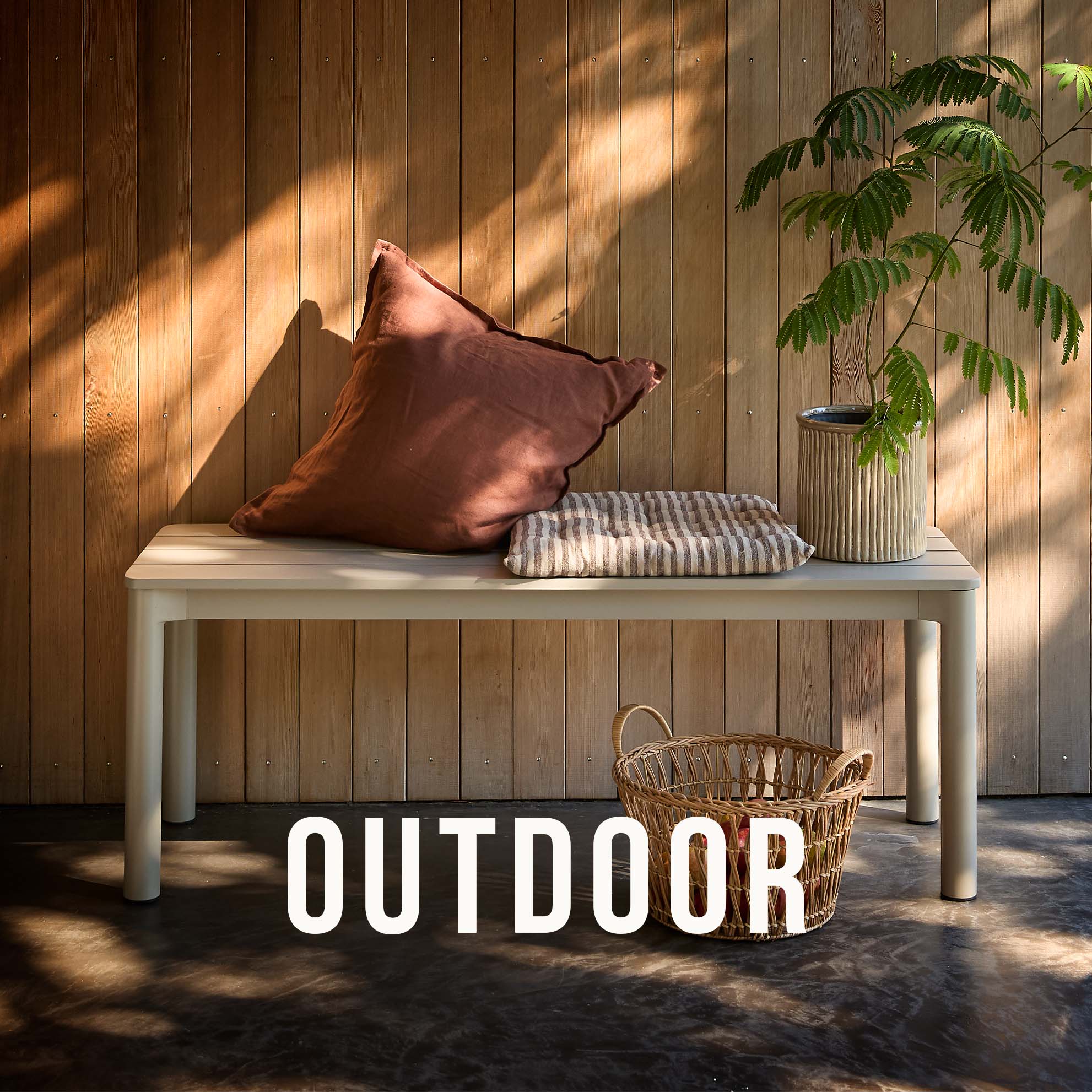 Trädgårdsbänk placerad utomhus med kuddar ovanpå.