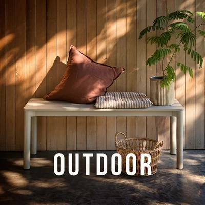 Trädgårdsbänk placerad utomhus med kuddar ovanpå.