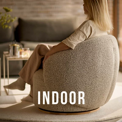 Kvinna sedd bakifrån som sitter i en grå fåtölj.